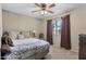 Comfortable bedroom with patterned bedding, ceiling fan, and natural light from the window at 2616 E Des Moines St, Mesa, AZ 85213