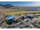 Aerial shot showcasing a modern community clubhouse, pool, golf course, and mountain views at 26689 W Ponderosa Ln, Buckeye, AZ 85396