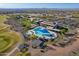 Luxury community aerial view features a resort-style pool, golf course, and desert landscape under a clear blue sky at 26689 W Ponderosa Ln, Buckeye, AZ 85396