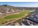 Stunning aerial view showcasing the community, a lush golf course, surrounding desert landscape and distant mountain views at 26689 W Ponderosa Ln, Buckeye, AZ 85396