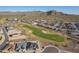 Aerial view showing community homes with a golf course, desert landscaping, and majestic mountains in the background at 26689 W Ponderosa Ln, Buckeye, AZ 85396