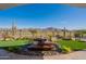 Backyard oasis showcases a tranquil water feature, lush landscaping, and mountain views at 26689 W Ponderosa Ln, Buckeye, AZ 85396