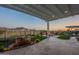 Inviting backyard oasis with covered patio, stone waterfall, and cozy fire pit area for outdoor relaxation at 26689 W Ponderosa Ln, Buckeye, AZ 85396