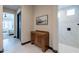 Hallway view to full bathroom with tiled shower and wooden cabinet at 26689 W Ponderosa Ln, Buckeye, AZ 85396