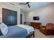 Bedroom featuring a bed, dresser, closet with sliding doors and a leather chair at 26689 W Ponderosa Ln, Buckeye, AZ 85396