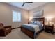 Comfortable bedroom showcasing a bed with a blue comforter, side tables, and shutters at 26689 W Ponderosa Ln, Buckeye, AZ 85396