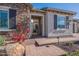 Inviting front entry featuring a stone facade, gated courtyard, and well-manicured landscaping at 26689 W Ponderosa Ln, Buckeye, AZ 85396