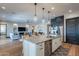 Stylish kitchen featuring a central island, stainless steel appliances, and seamless flow to the living area at 26689 W Ponderosa Ln, Buckeye, AZ 85396