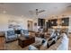 Spacious open-plan living room with hardwood floors, a ceiling fan, and an adjoining modern kitchen at 26689 W Ponderosa Ln, Buckeye, AZ 85396