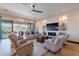 Bright living room features hardwood floors, built-in shelving, fireplace, and sliding glass doors to the patio at 26689 W Ponderosa Ln, Buckeye, AZ 85396