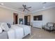 Well-lit bedroom with a ceiling fan, TV, dresser, and comfortable seating at 26689 W Ponderosa Ln, Buckeye, AZ 85396