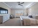 Comfortable bedroom features a ceiling fan, large windows, and plush decor at 26689 W Ponderosa Ln, Buckeye, AZ 85396