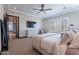 Spacious main bedroom with a ceiling fan, large TV, and ample natural light from plantation shutters at 26689 W Ponderosa Ln, Buckeye, AZ 85396