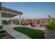 Relaxing outdoor patio features a covered seating area, fire pit with Adirondack chairs, and golf course views at 26689 W Ponderosa Ln, Buckeye, AZ 85396