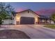 Two-car garage and landscaped yard in front of single-story home with brick accents and neutral stucco at 2726 E Hale St, Mesa, AZ 85213