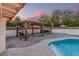 This beautiful outdoor gazebo, features a swing, seating area, and outdoor grill, perfect for summer evenings at 2726 E Hale St, Mesa, AZ 85213