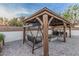 Outdoor gazebo with covered swing, outdoor grill, and stone firepit area, creating an inviting outdoor gathering space at 2726 E Hale St, Mesa, AZ 85213