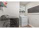 Efficient laundry area with modern appliances and functional shelving for storage at 2726 E Hale St, Mesa, AZ 85213
