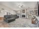 Open-concept living room with vaulted ceiling, fireplace, built-in shelving, and kitchen access at 2726 E Hale St, Mesa, AZ 85213