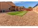 Spacious gravel backyard with a hot tub, artificial grass, and a covered patio at 29193 N Mountain View Rd, San Tan Valley, AZ 85143