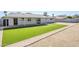 Large backyard featuring artificial turf, a covered patio, and white brick exterior at 3138 N 82Nd Pl, Scottsdale, AZ 85251