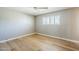 Bright bedroom featuring light wood floors, ceiling fan, and white shuttered windows at 3138 N 82Nd Pl, Scottsdale, AZ 85251