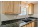 The kitchen features light wood cabinets, granite countertops and a stainless steel sink at 3138 N 82Nd Pl, Scottsdale, AZ 85251