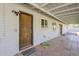 Covered patio featuring brick flooring, a wooden door, and outdoor lighting at 3138 N 82Nd Pl, Scottsdale, AZ 85251
