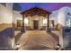 Inviting home entrance with a covered porch, stone pillars, desert landscaping, and warm exterior lighting at 3333 N 87Th St, Mesa, AZ 85207