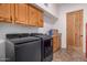 Modern laundry room featuring a front-load washer and dryer and wood cabinets at 3333 N 87Th St, Mesa, AZ 85207