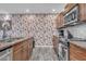 Kitchen area with stainless steel appliances, granite countertops, wood cabinets and patterned wallpaper at 4020 N 34Th St, Phoenix, AZ 85018