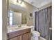 Bathroom with wood vanity, sink, toilet, and polka-dot shower curtain at 40845 W Thornberry Ln, Maricopa, AZ 85138