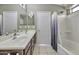 Bright bathroom featuring double sinks, large mirror, a toilet and a shower at 40845 W Thornberry Ln, Maricopa, AZ 85138