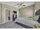 Comfortable bedroom with ceiling fan, bathroom access, carpet and dresser at 40845 W Thornberry Ln, Maricopa, AZ 85138