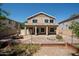 Back exterior of a two-story home with a covered patio, a fountain, and a well-maintained yard at 4349 E Windsor Ct, Gilbert, AZ 85296
