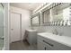 Well-lit bathroom features dual sinks with framed mirrors, complemented by unique tile floors and modern fixtures at 4349 E Windsor Ct, Gilbert, AZ 85296