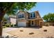 Tan two story home with a two car garage and a gravel yard at 4349 E Windsor Ct, Gilbert, AZ 85296