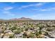 Vibrant aerial shot showcases a neighborhood with homes, lush trees, and majestic mountains under a clear sky at 4645 E Cambridge Ave, Phoenix, AZ 85008