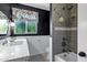 Stylish bathroom featuring dark walls, decorative wallpaper, a marble countertop, and a tub with a shower at 4645 E Cambridge Ave, Phoenix, AZ 85008
