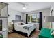 Sunlit bedroom features a striped headboard, decorative pillows, a modern side table, and hardwood floors at 4645 E Cambridge Ave, Phoenix, AZ 85008