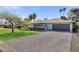 Attractive single-story home with a brick driveway, lush lawn, and meticulously maintained front yard at 4645 E Cambridge Ave, Phoenix, AZ 85008