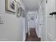 Bright hallway featuring hardwood floors, white walls adorned with framed photos, and black door hardware at 4645 E Cambridge Ave, Phoenix, AZ 85008