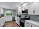Bright kitchen featuring stainless steel appliances, white cabinets, and wood flooring at 4645 E Cambridge Ave, Phoenix, AZ 85008
