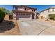 View of two-story home featuring a two car garage and desert landscaping at 4826 S 26Th Ln, Phoenix, AZ 85041