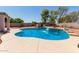 Beautiful in-ground pool is surrounded by a concrete patio and block wall for privacy and is landscaped with blooming plants at 4826 S 26Th Ln, Phoenix, AZ 85041