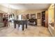Open concept space with travertine tile and foosball table, flowing to the kitchen, with decorative accents at 5616 E Desert Vista Trl, Cave Creek, AZ 85331