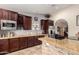 Contemporary kitchen with granite countertops, stainless steel appliances, dark wood cabinets, and travertine flooring at 5616 E Desert Vista Trl, Cave Creek, AZ 85331