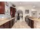 Chef's kitchen with granite countertops, stainless steel appliances, dark wood cabinetry, and travertine flooring at 5616 E Desert Vista Trl, Cave Creek, AZ 85331