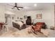 Bright living room with travertine tile, stone fireplace, ceiling fan, comfortable seating, and an arched doorway at 5616 E Desert Vista Trl, Cave Creek, AZ 85331