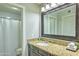 Well-lit bathroom with granite countertops, dark cabinets, and large mirror above the sink at 5950 N 78Th St # 102, Scottsdale, AZ 85250